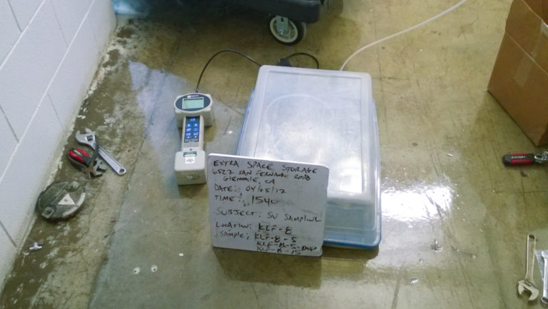 tools and meters used for air quality testing laying on floor of site