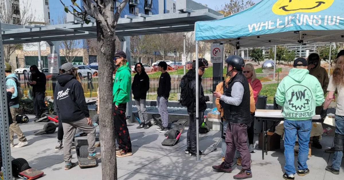 People walk around an outdoor event with pop-up tents