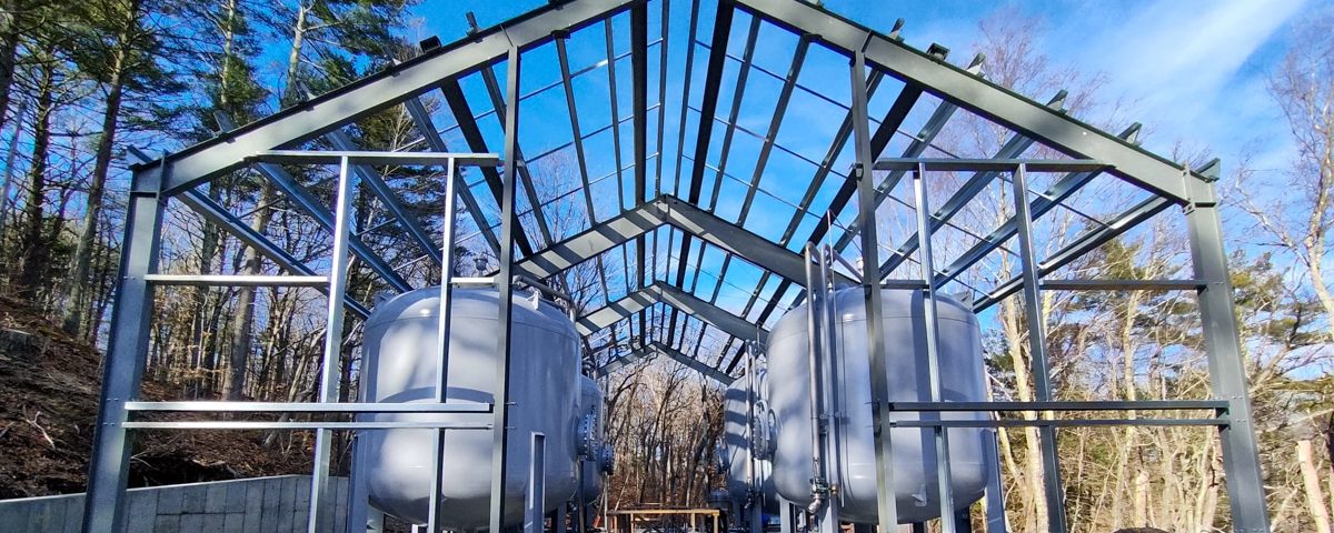 drinking water wells site during construction building frame with tanks and blue sky