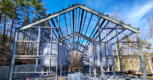 drinking water wells site during construction building frame with tanks and blue sky