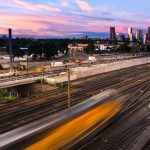 Commuter rail train on tracks at sunset