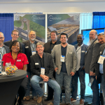 CMAA2024 conference attendees Tim Bayes, Rich Fitterer, Terri London, Thomas Fakner, Ken Bohannan, Scott Maloney, John Pollock, Derick London, Jeremy Mason, Sean Murphy, Brian Kisner, and Jamil Al Amamreh pose at booth