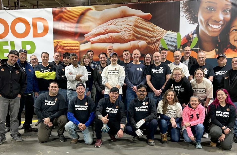 Volunteer group poses in front of food bank banner