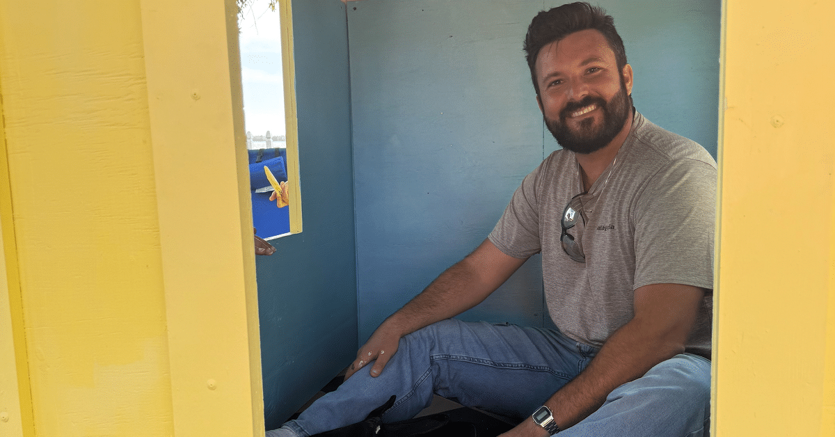 Habitat LS Jingle-Build 1200x628 -6 Photo of Kleinfelder staff member sitting inside playhouse during Habitat for Humanity's Jingle Build-Off