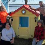Kleinfelder staff posing with their Bluey-themed playhouse for Habitat for Humanity's Jingle Build-Off