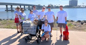 Group of people stand with collected debris on Coastal Cleanup Day