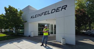 Person in safety gear standing in front of Kleinfelder building entrance