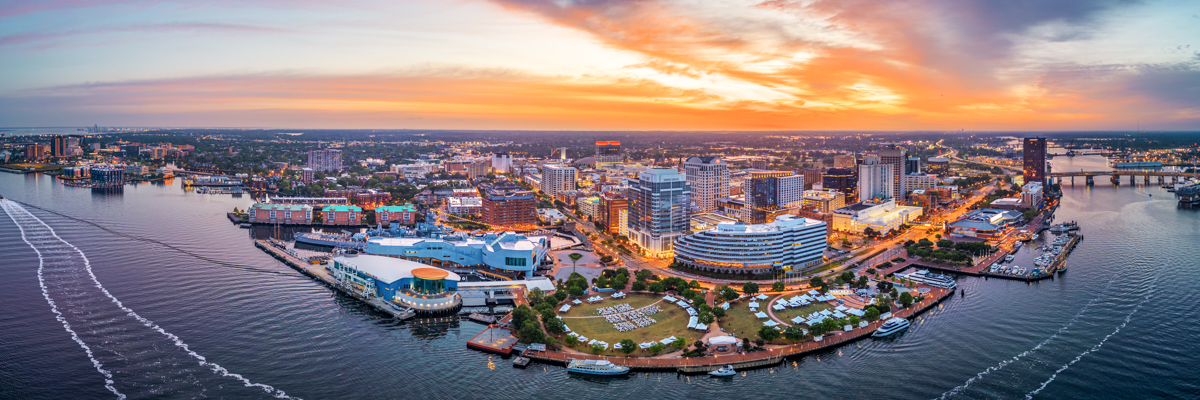 Norfolk, Virginia, USA downtown city skyline from over the Elizabeth River at dusk.