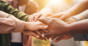 Stock image of hands reaching in depicting volunteering together