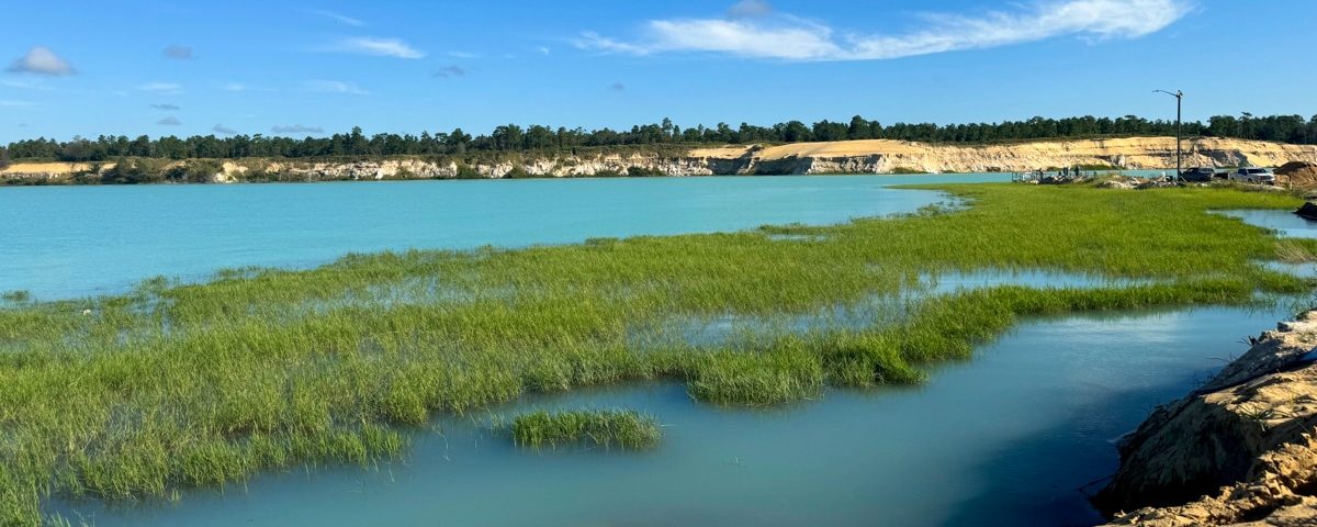 view of sand mine from shore with water