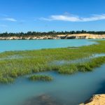view of sand mine from shore with water