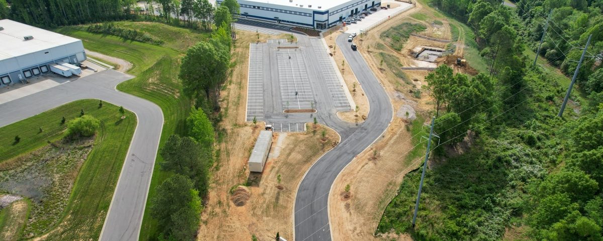 refuse truck manufacturing facility aerial view with roadway and large building