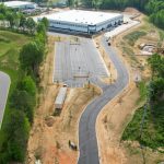 refuse truck manufacturing facility aerial view with roadway and large building