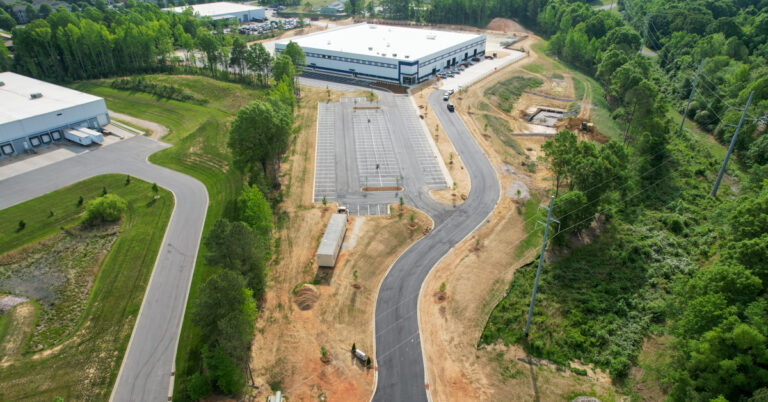 refuse truck manufacturing facility aerial view with roadway and large building