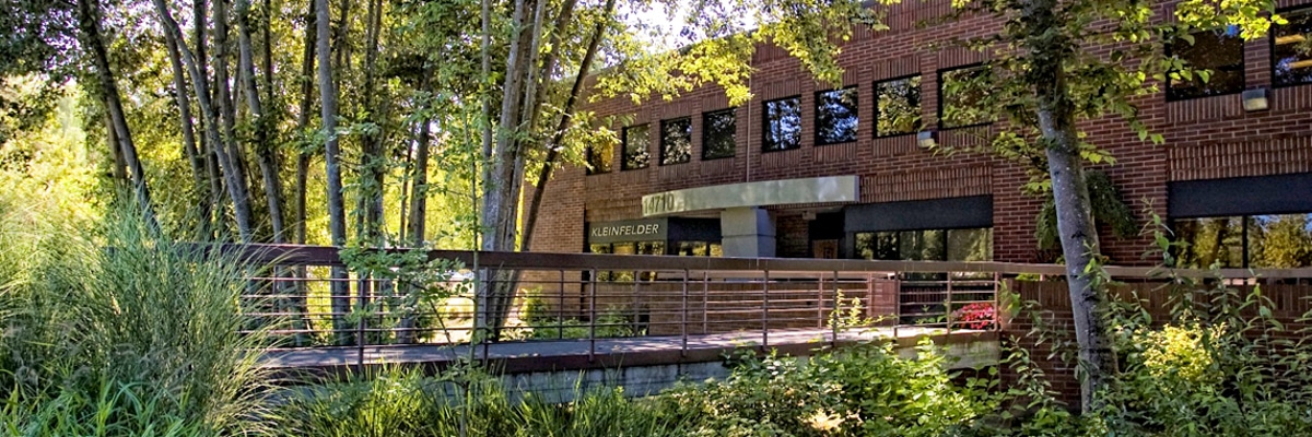 entrance to Seattle office building with footbridge and trees