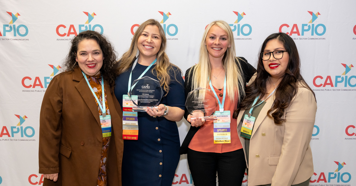 CAPIO25 four attendees at conference holding award in front of logo background
