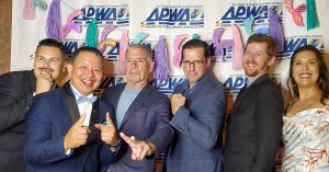 Kleinfelder project staff at event gala in front of logo branded backdrop