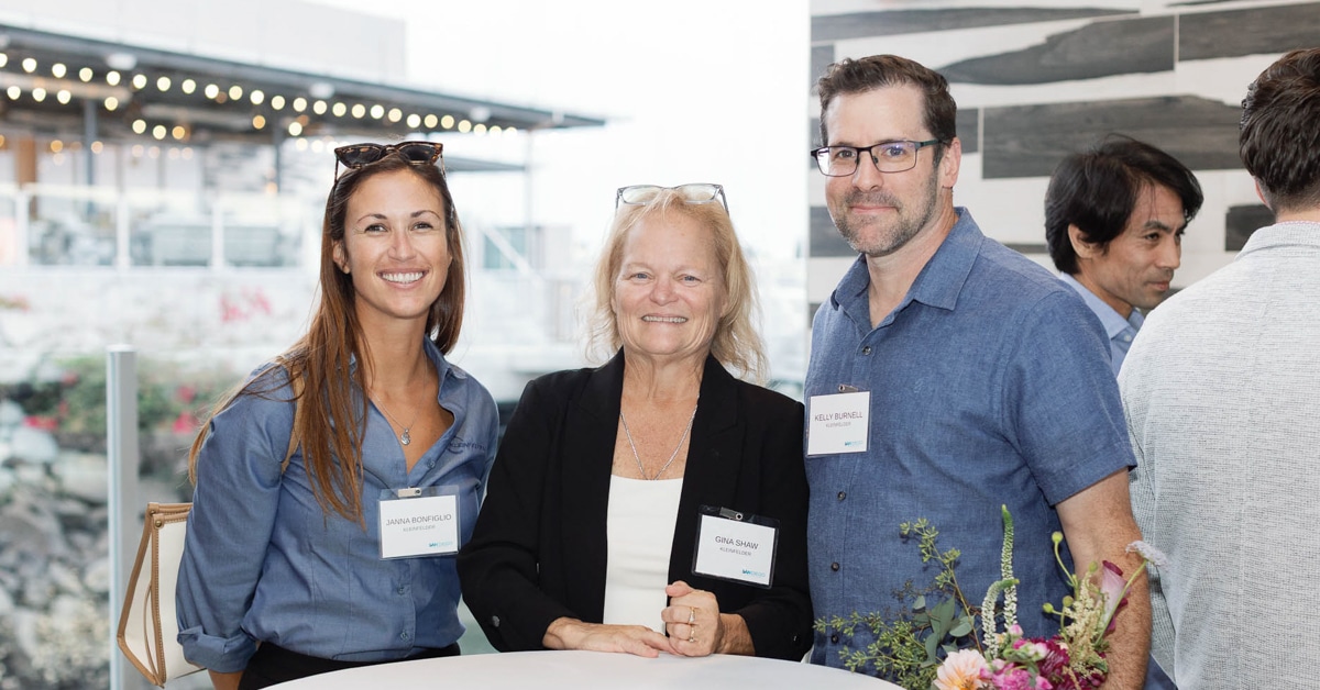 20251010-250925 Gensler-195 Three people pose at table during event ceremony