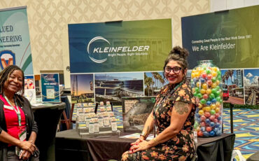 Two people at exhibit booth at Mobility 21 conference