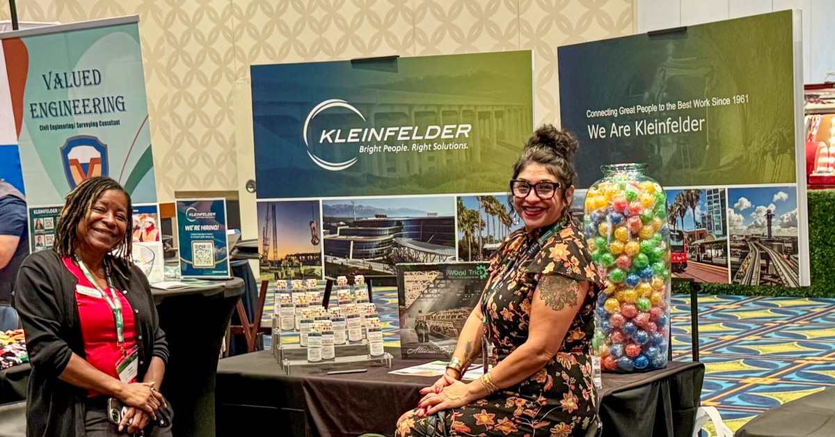 Two people at exhibit booth at Mobility 21 conference