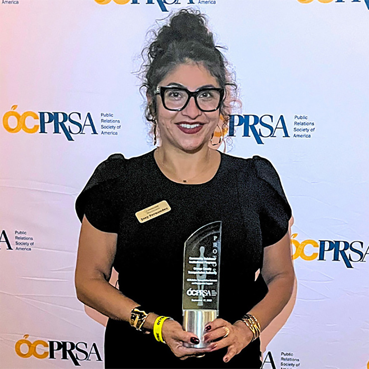 person holding award in front of logo backdrop