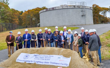 Straightway Water Treatment facility groundbreaking ceremony group of people with shovels and dirt in front of water tank