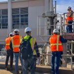 San Diego Pump Station 1 group in safety gear standing in front of small white building