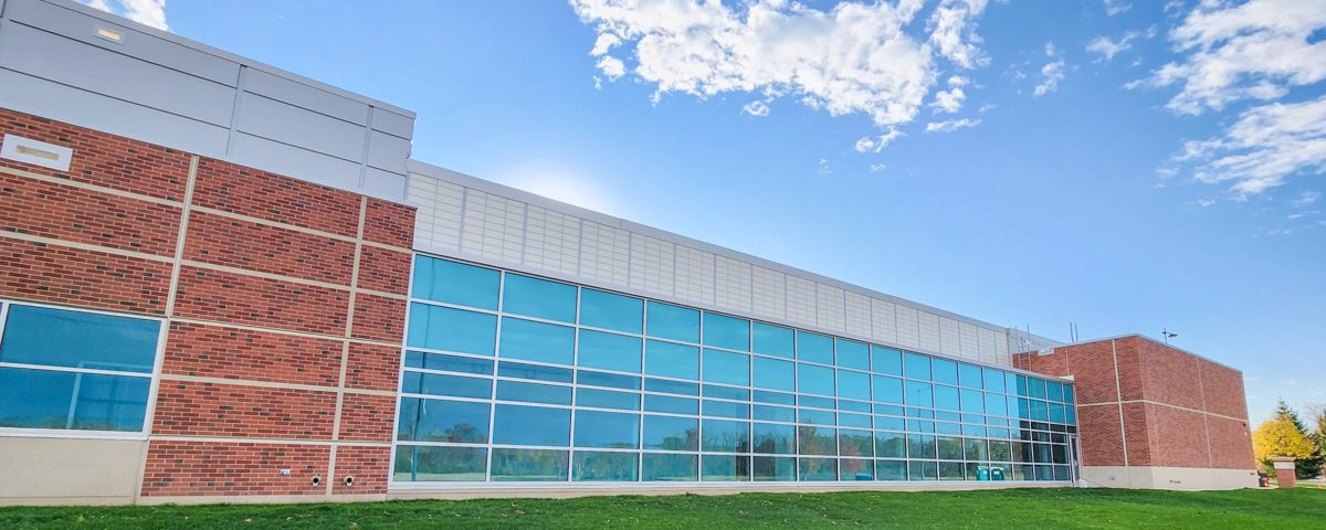 Laboratory classroom building outside with tall windows on brick facade on sunny day
