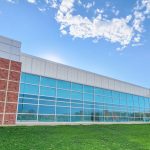 Laboratory classroom building outside with tall windows on brick facade on sunny day