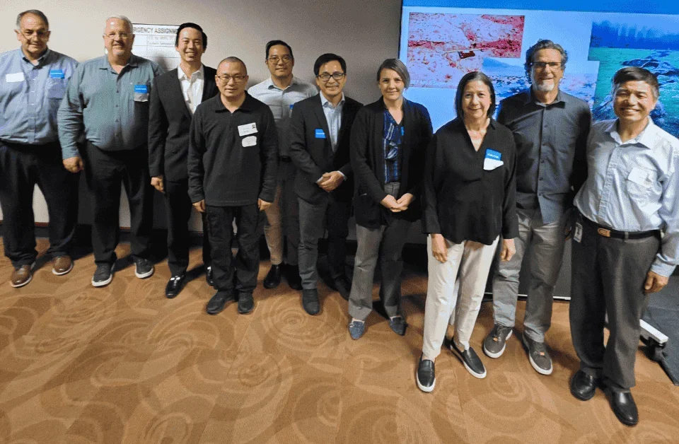 Group standing in front of screen posing for photo