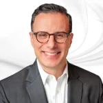 Nick Mitrakis headshot on white marble background