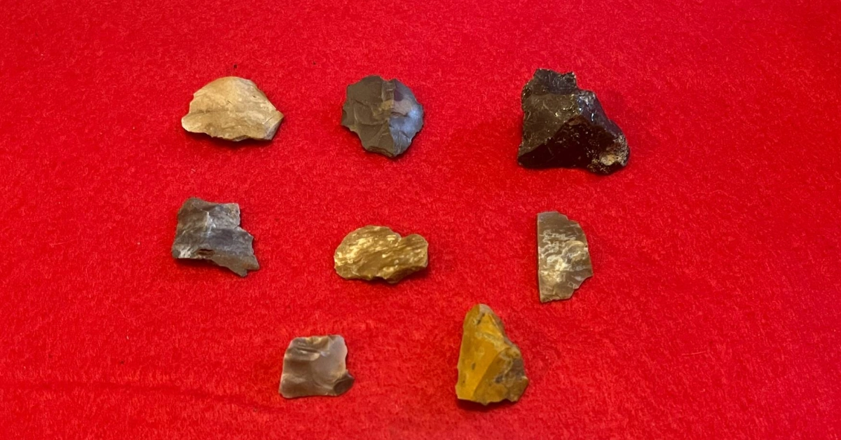 Various stones arranged on red fabric.