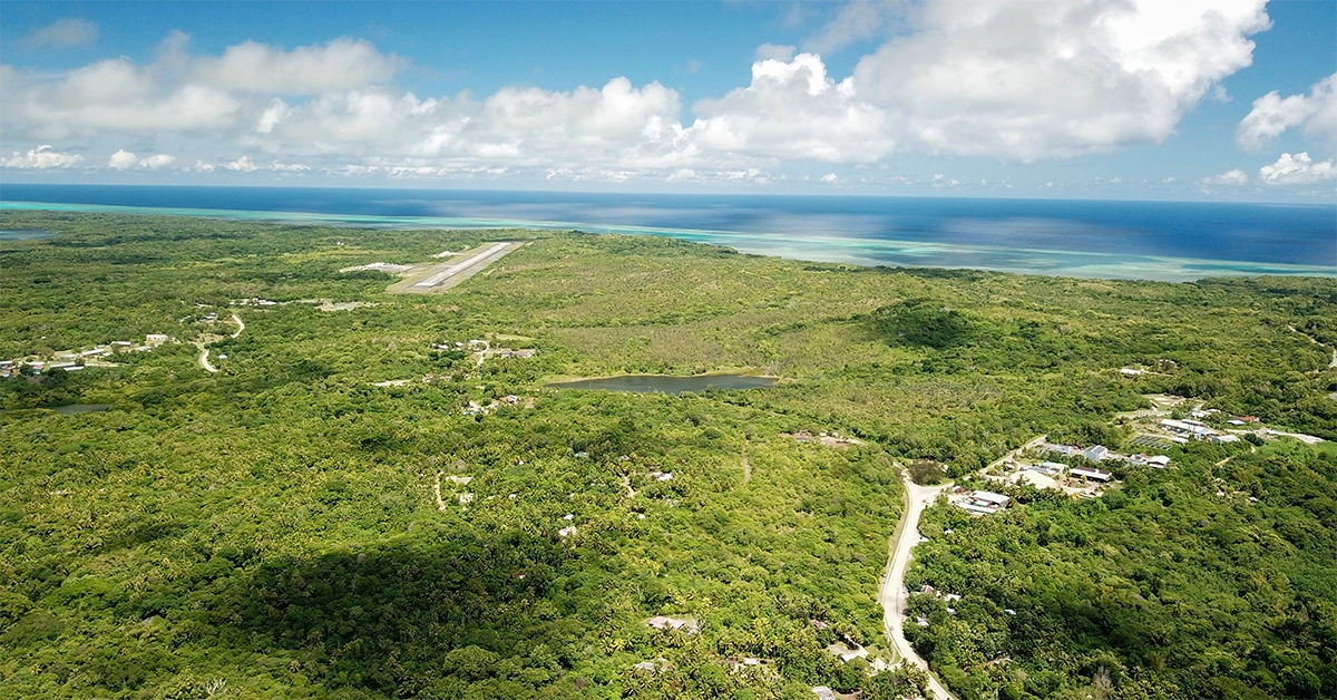 Yap city, FSM, aerial view showing dense tree cover and airstrip in distance